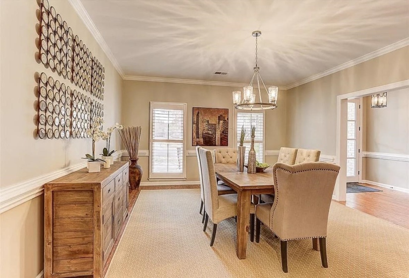 Formal dining area featuring a tray ceiling, crown molding, and two large windows with plantation shutters