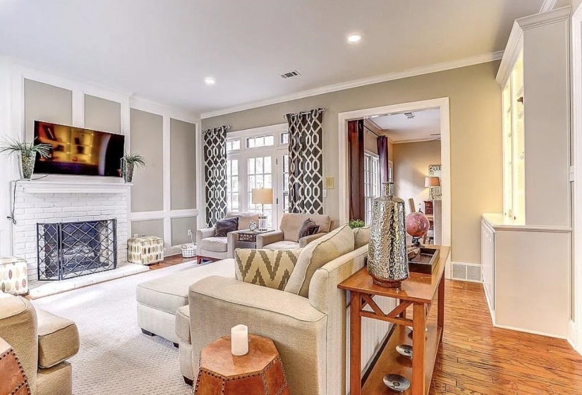 Living area featuring a painted brick fireplace with a decorative screen