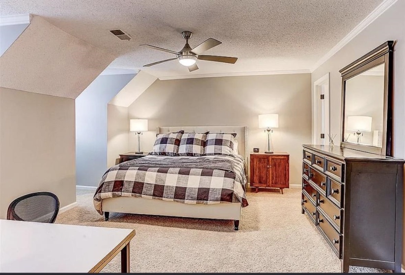 Carpeted room with a sloped ceiling and neutral wall tones