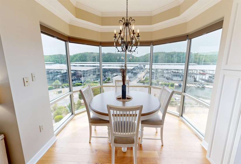 Dining area featuring panoramic windows, hardwood flooring, an ornate chandelier, and built-in white cabinetry