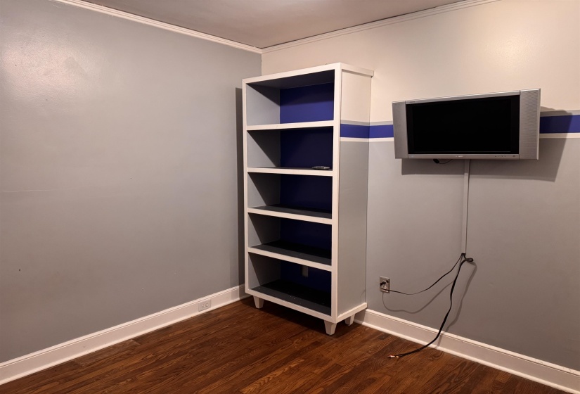 Room featuring wood-finish flooring, white baseboards, and two-tone wall paint