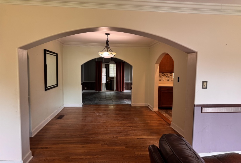 Hardwood flooring extending through an arched entryway