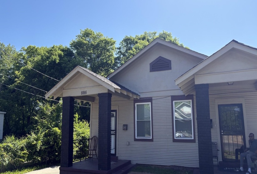 Gable-roofed facade with contrasting trim and a covered front porch featuring square columns
