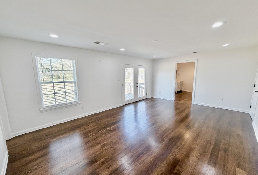 Unfurnished room with french doors, healthy amount of natural light, dark hardwood flooring, and recessed lighting