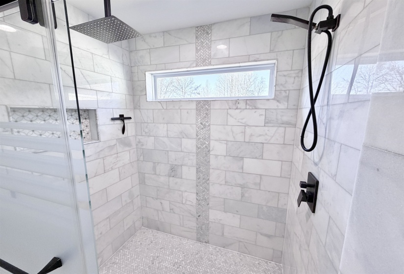 Large marble walk in shower with rain feature and variable shower head.