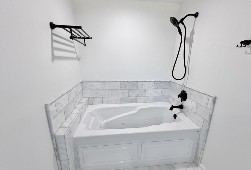 Heated jetted jacuzzi tub, with marble surround and upgraded variable lighting with blue tooth compatible speaker.