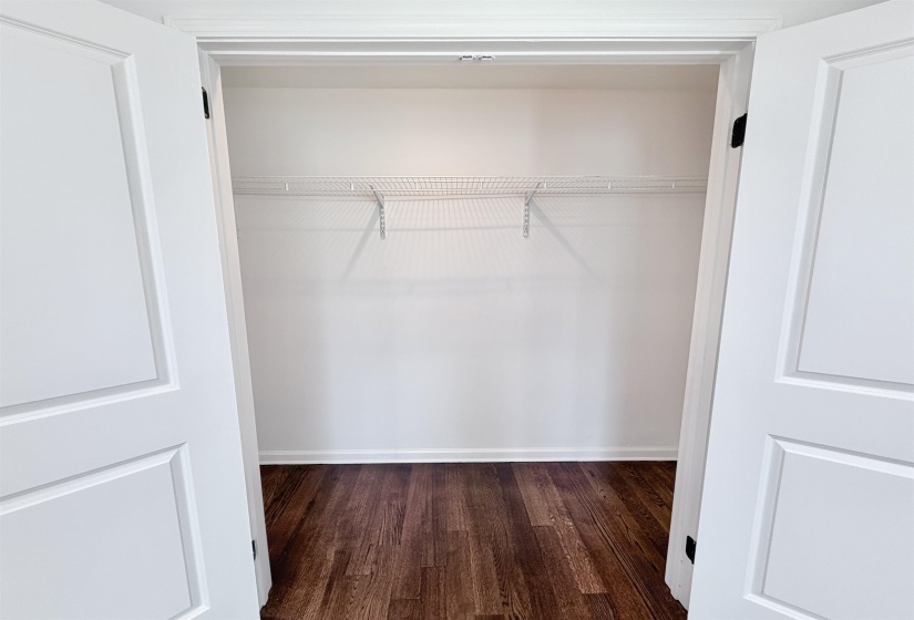 Large closet with hardwood floors and recessed lighting