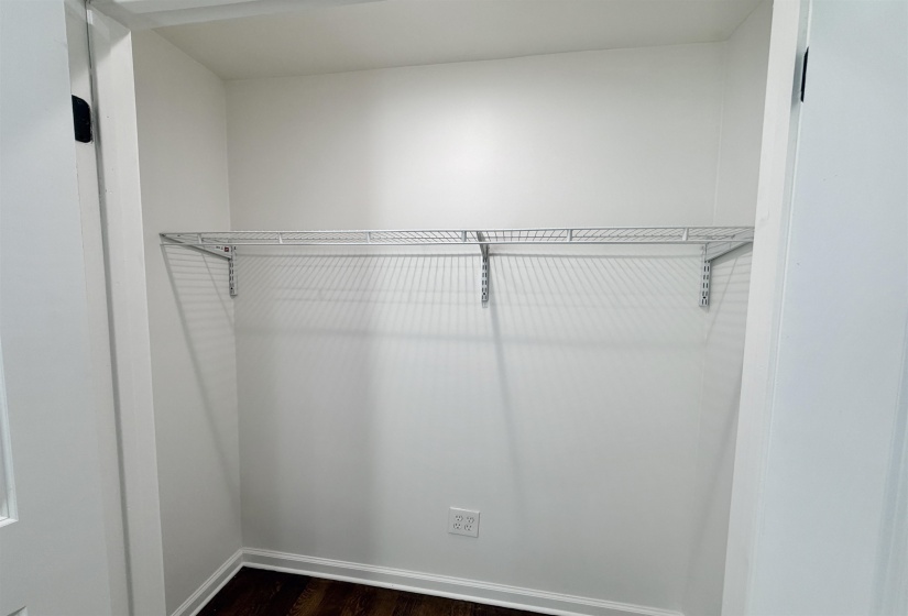Large closet featuring dark hardwood flooring