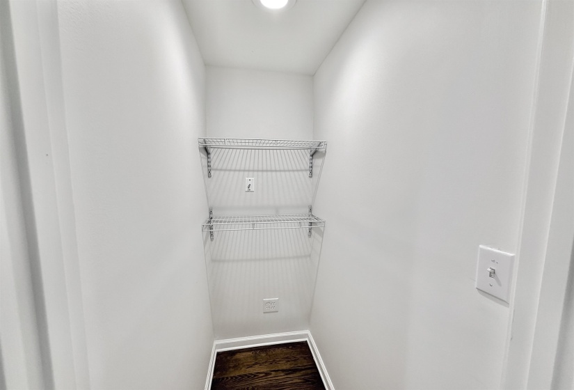 Walk in closet with separate heating and air vent and electrical outlets for router and office equipment.  Features dark hardwood floors and recessed lighting.