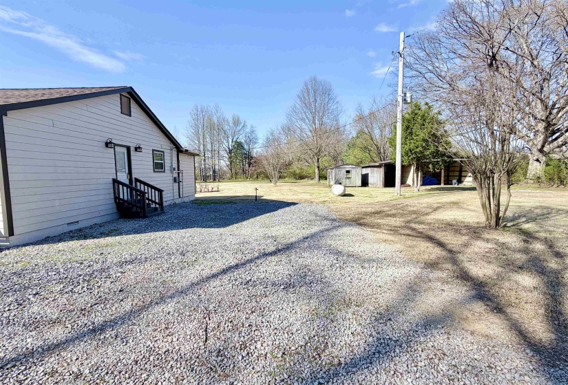 View of green lawn featuring an outbuilding