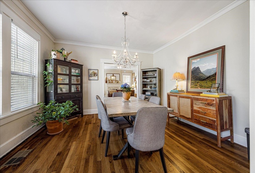 Hardwood flooring extends throughout this room, featuring a white trim package and crown molding
