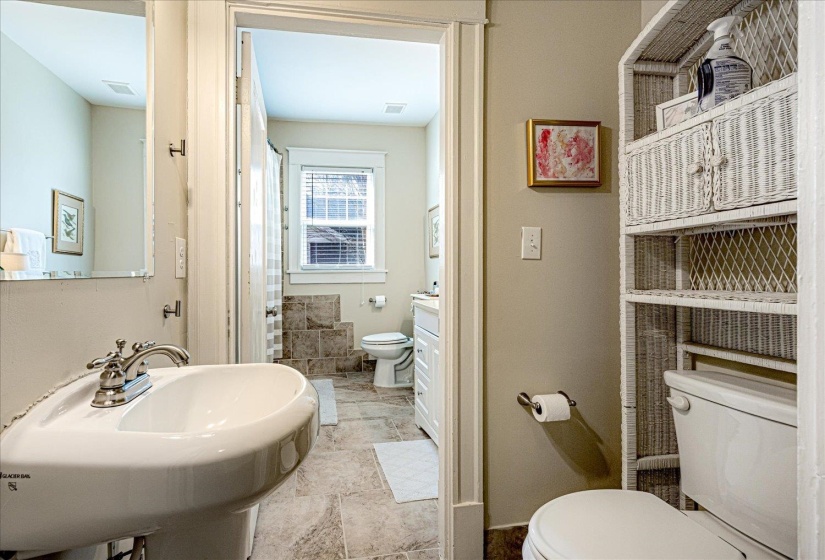 Pedestal sink with chrome fixtures and a vanity mirror
