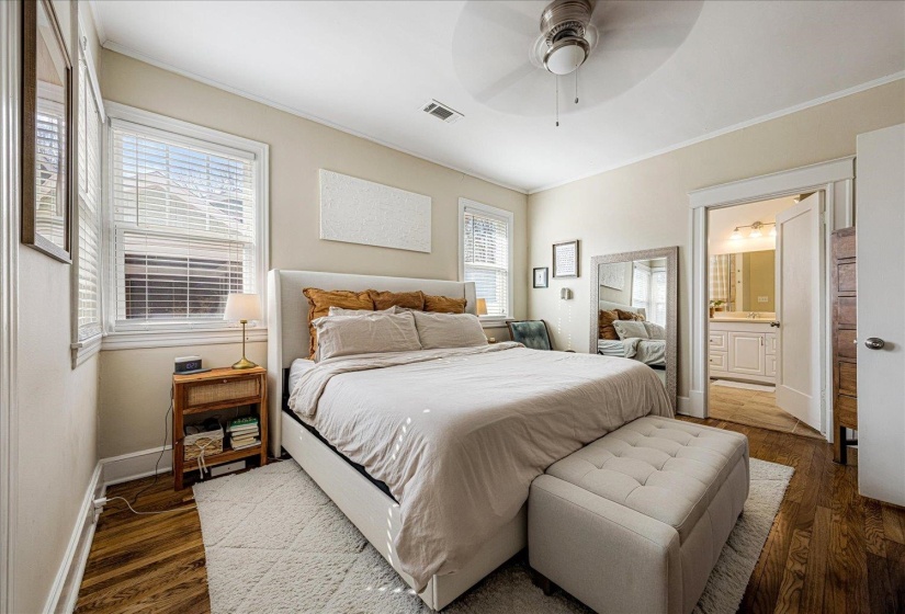 Hardwood flooring extends throughout this room, complemented by a ceiling fan with integrated lighting