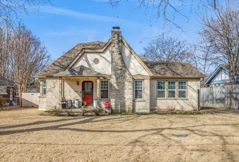 Stone and stucco facade home with a prominent stone chimney