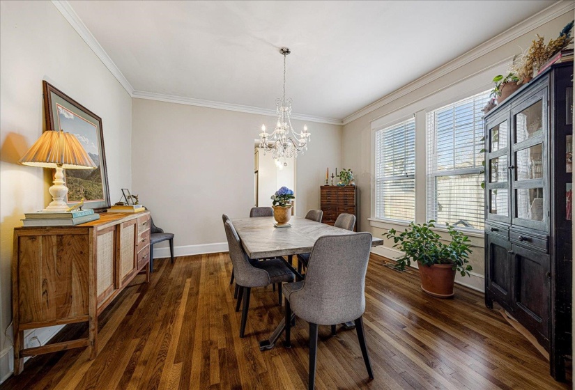 Spacious interior featuring wood-finish flooring, white baseboards, and elegant crown molding