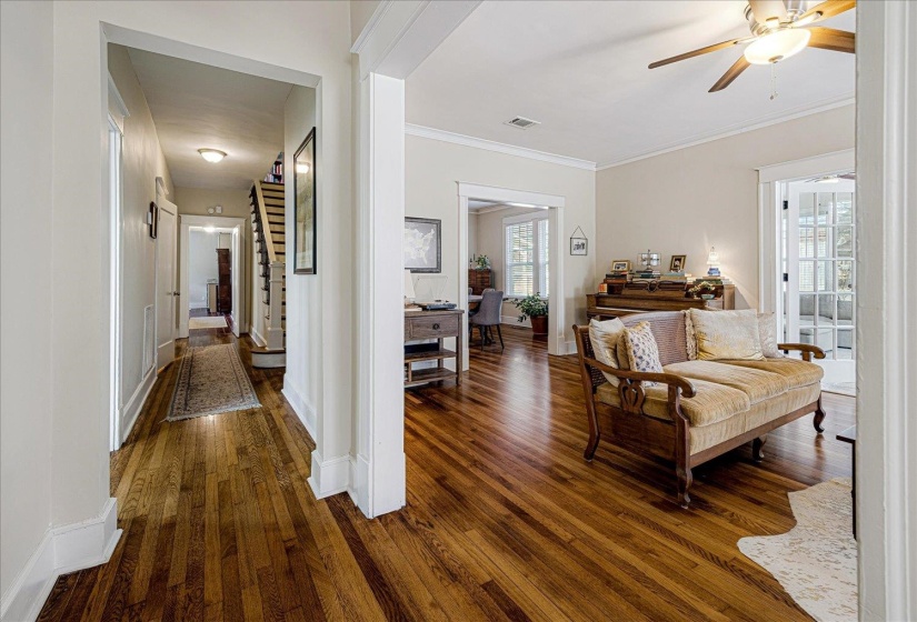Hardwood flooring extends throughout the main living areas, featuring a spacious room with a ceiling fan
