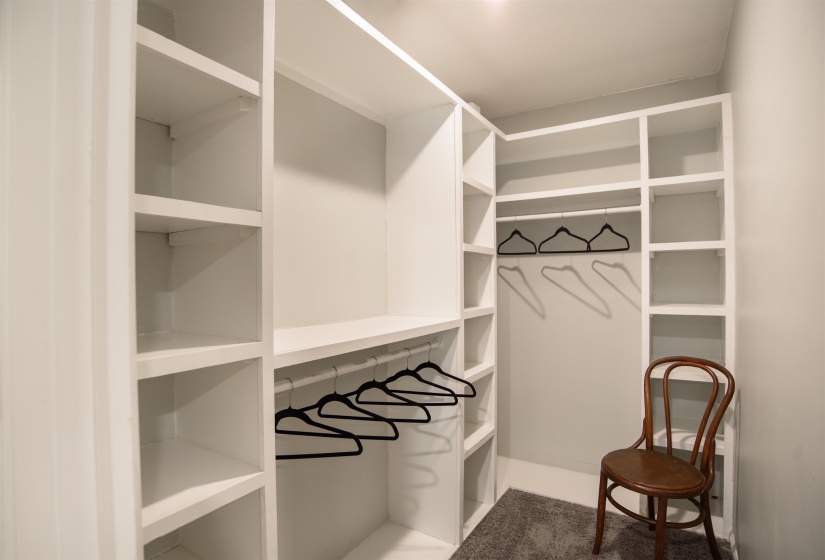 Custom built-in closet system featuring white shelving and hanging rods