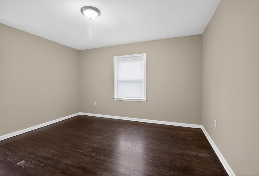 Room featuring wood-finish flooring, neutral wall paint, and white trim