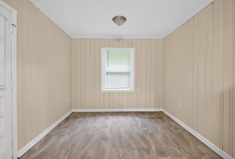Neutral-toned vertical paneling throughout the room, complemented by wood-finish flooring