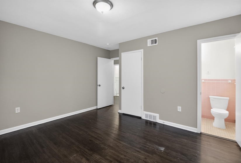 Dark wood-finish flooring with light gray walls and white trim