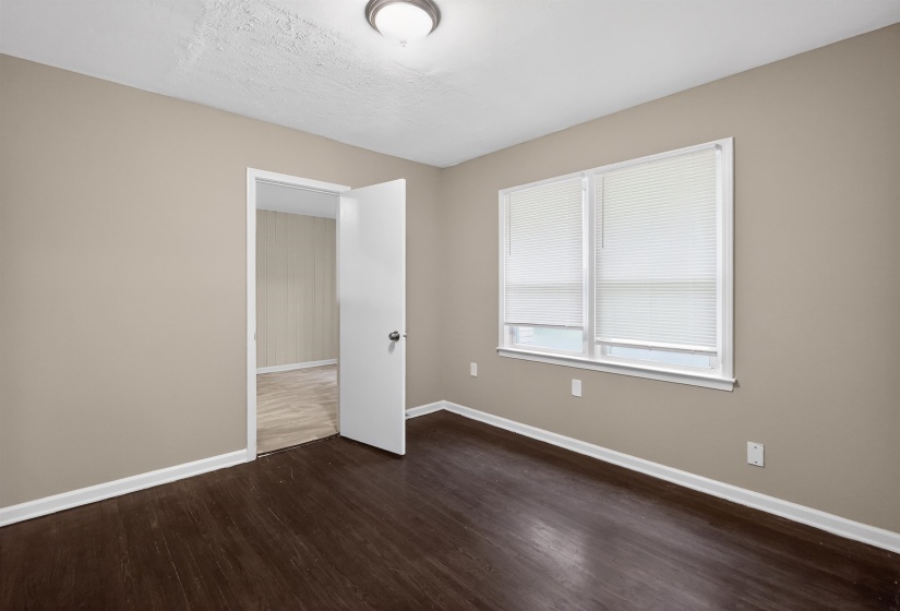 Interior room featuring wood-finish flooring, neutral wall paint, and white trim