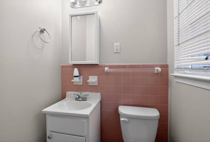 Bathroom featuring a white vanity with integrated sink, chrome faucet, and a wall-mounted medicine cabinet