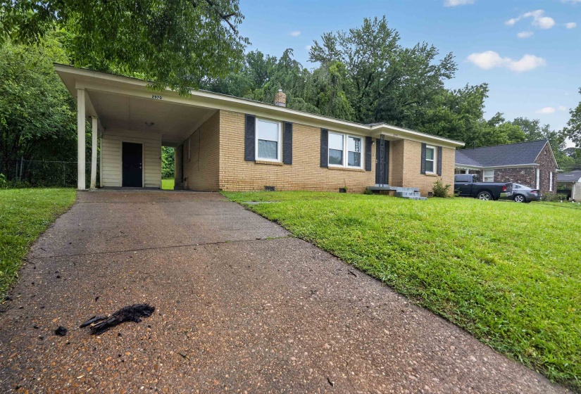 Brick-faced residence featuring a covered carport, concrete driveway, and a front entry with three steps