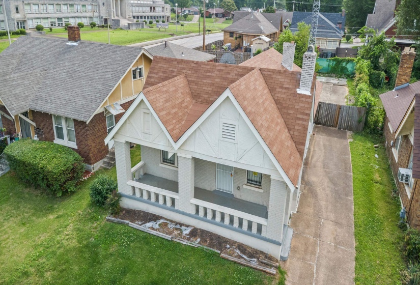 Gabled bungalow with a front porch, white exterior, and a brown shingle roof