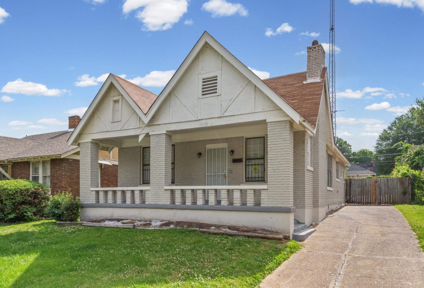 Brick facade home featuring a covered front porch with column supports and a decorative railing