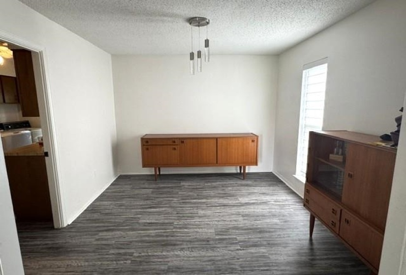 Dining area with wood-finish flooring, white walls, and a contemporary multi-light pendant fixture