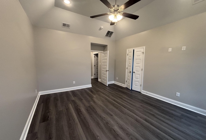 Spacious interior room featuring vaulted ceilings, recessed lighting, and wood-finish flooring