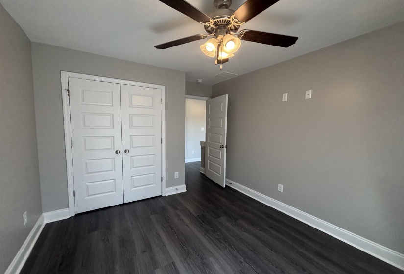 Room featuring wood-finish flooring, neutral wall paint, and white baseboards
