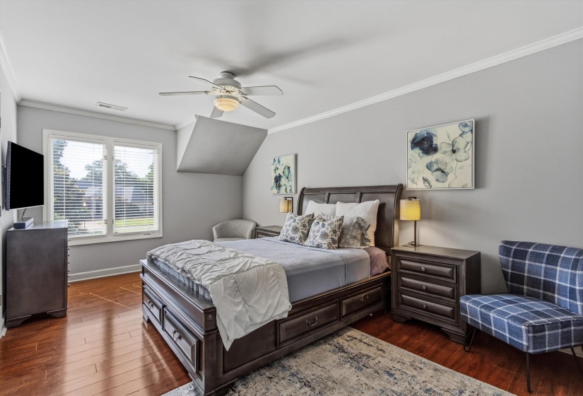 Spacious room featuring rich wood-finish flooring and light grey walls
