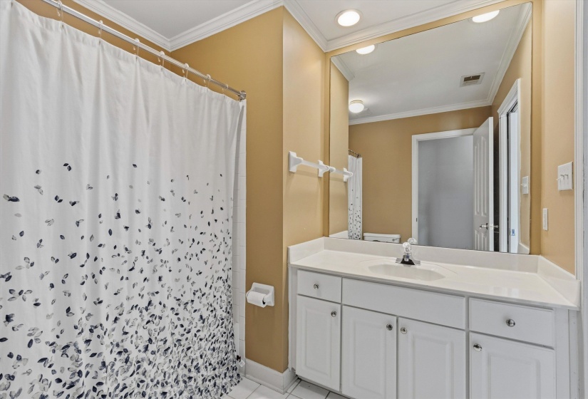 Bathroom featuring a white vanity with integrated sink, a large wall-mounted mirror, and recessed lighting