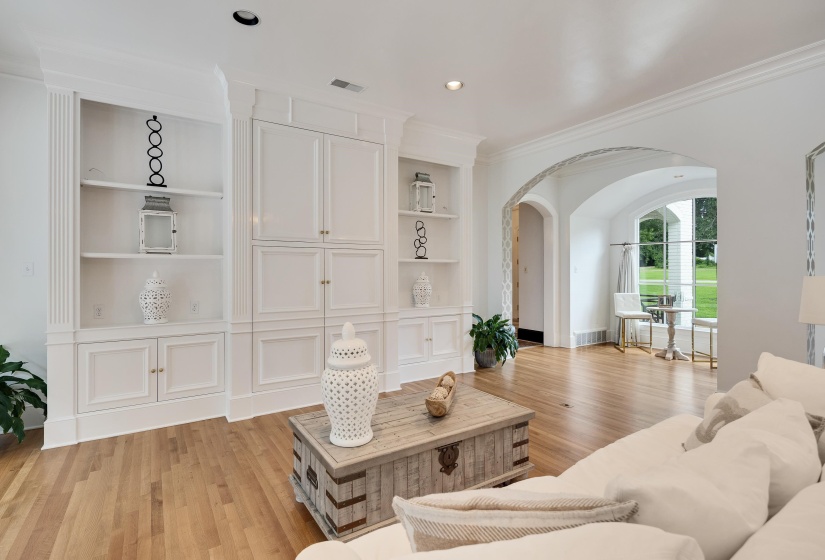 Living area featuring extensive built-in cabinetry, shelving, and a media center