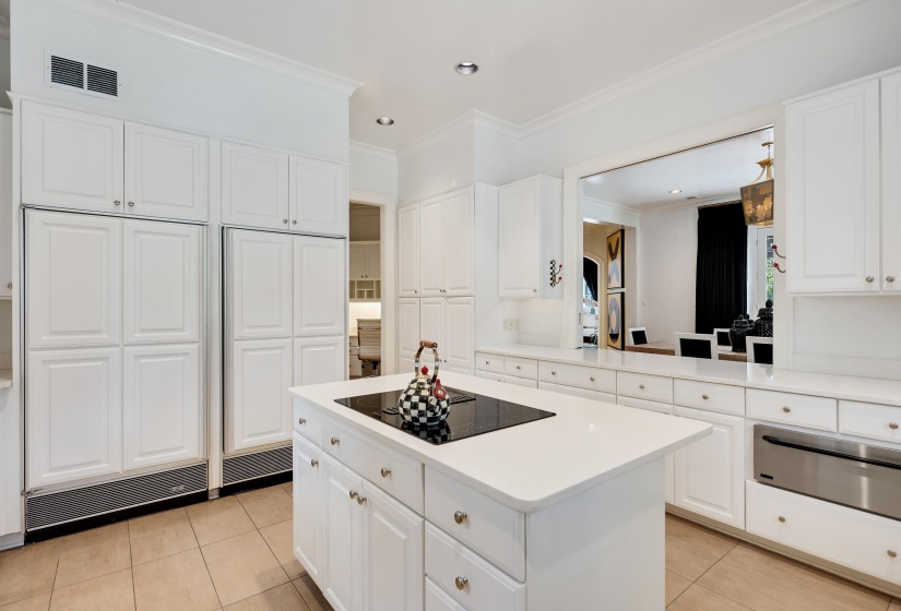 Kitchen featuring an expansive center island with an integrated cooktop, white cabinetry, integrated refrigeration, tile flooring, and recessed lighting