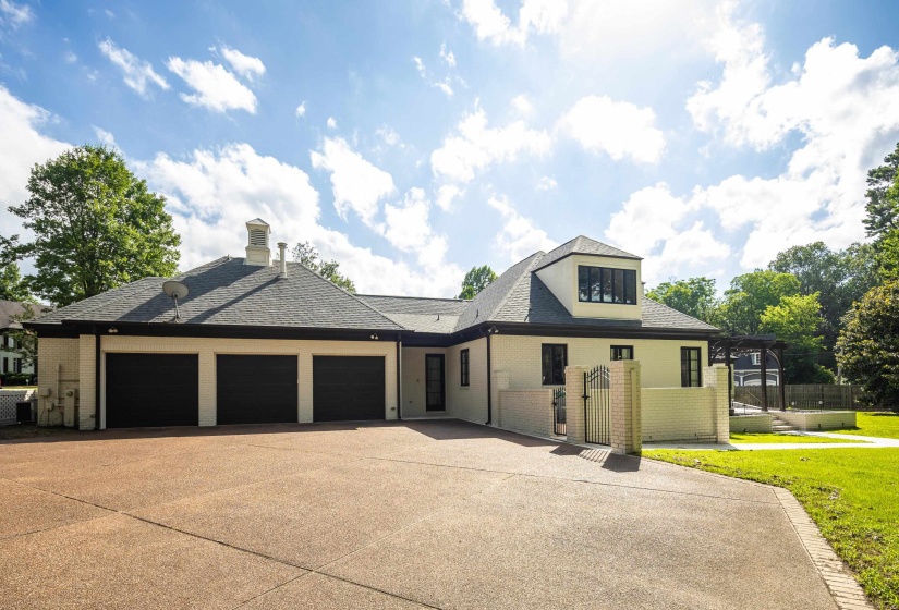Expansive paved driveway leading to a three-car garage