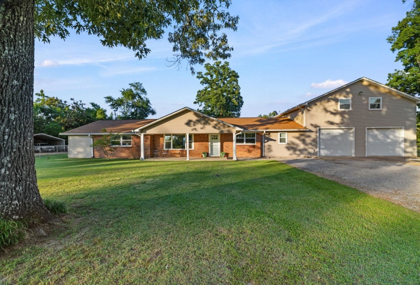 Ranch-style residence featuring a brick facade, covered front porch with white columns, and a front entry door with sidelights