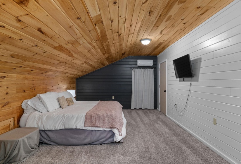 Sloped wood-paneled ceiling with recessed lighting