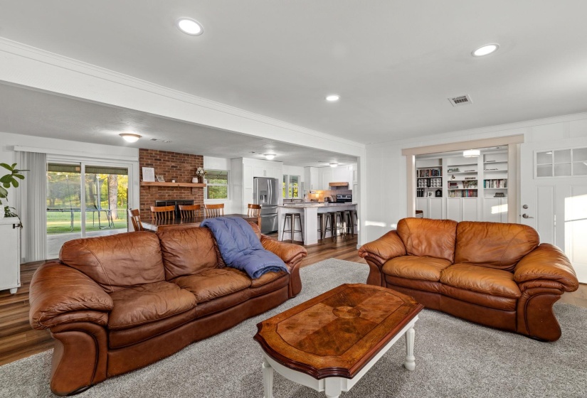 Open-concept living space featuring wood-finish flooring, recessed lighting, and white trim