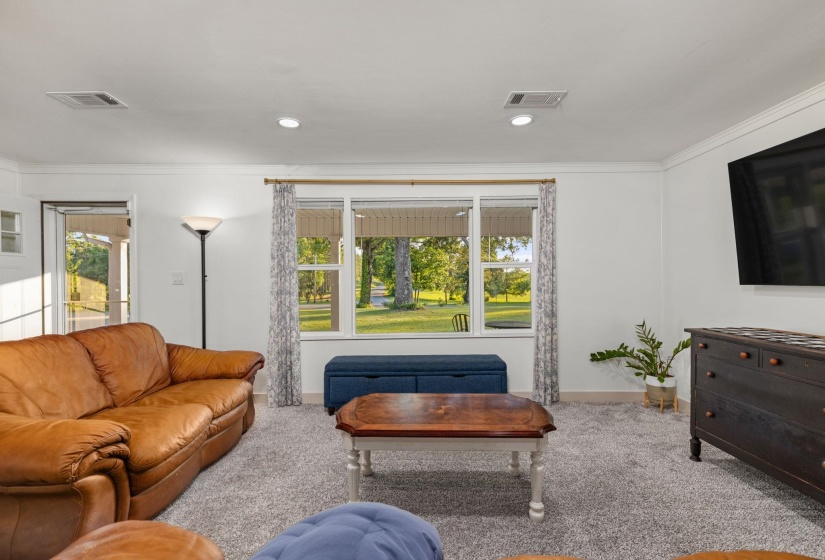 Living area featuring a large picture window, recessed lighting, crown molding, and plush carpeting