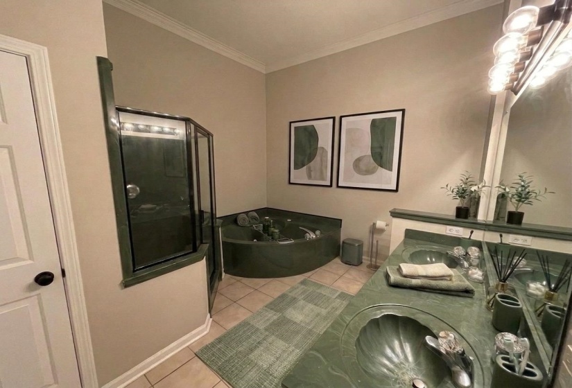 Bathroom featuring a corner jetted tub, a separate glass-enclosed shower, and a dual vanity with integrated sinks