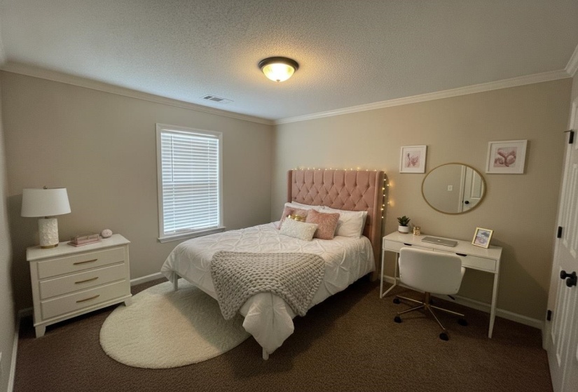 Bedroom featuring neutral wall paint and crown molding