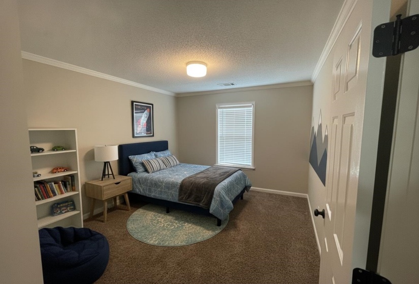 Carpeted room featuring crown molding, a single window with blinds, and a flush-mount ceiling light