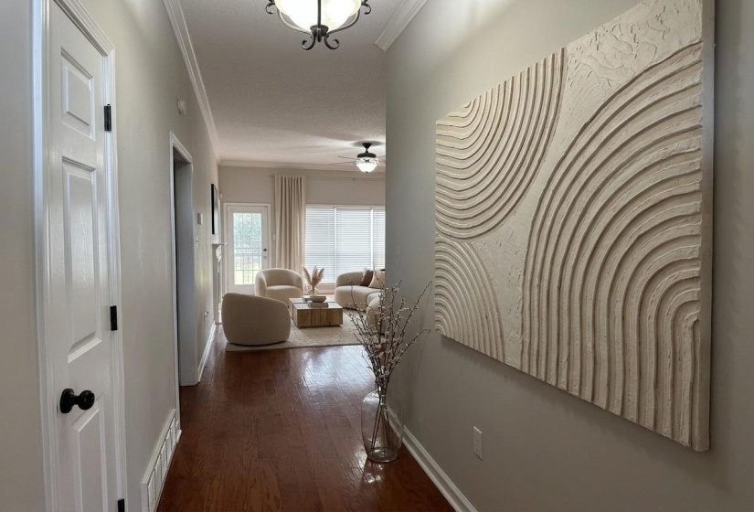 Hallway with wood-finish flooring, crown molding, and recessed lighting