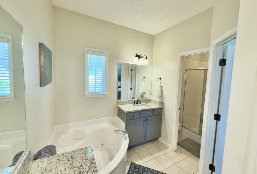 Full bathroom with a shower stall, a tub with jets, vanity, and tile patterned floors