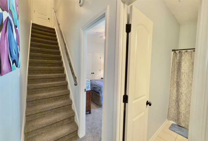 Staircase with tile patterned flooring and ceiling fan