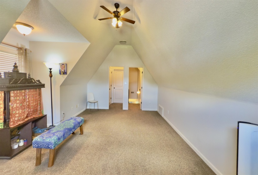 Bonus room with ceiling fan, vaulted ceiling, carpet floors, and a textured ceiling