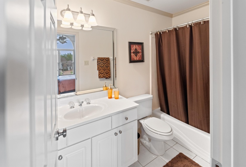 Full bathroom featuring shower / tub combo, vanity, tile patterned flooring, ornamental molding, and toilet