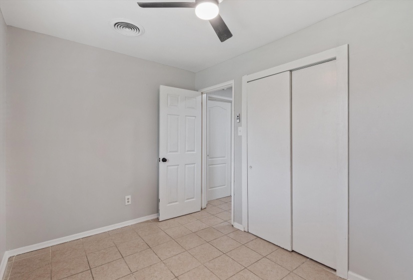 Room featuring neutral-toned walls, tile flooring, and a ceiling fan with integrated lighting